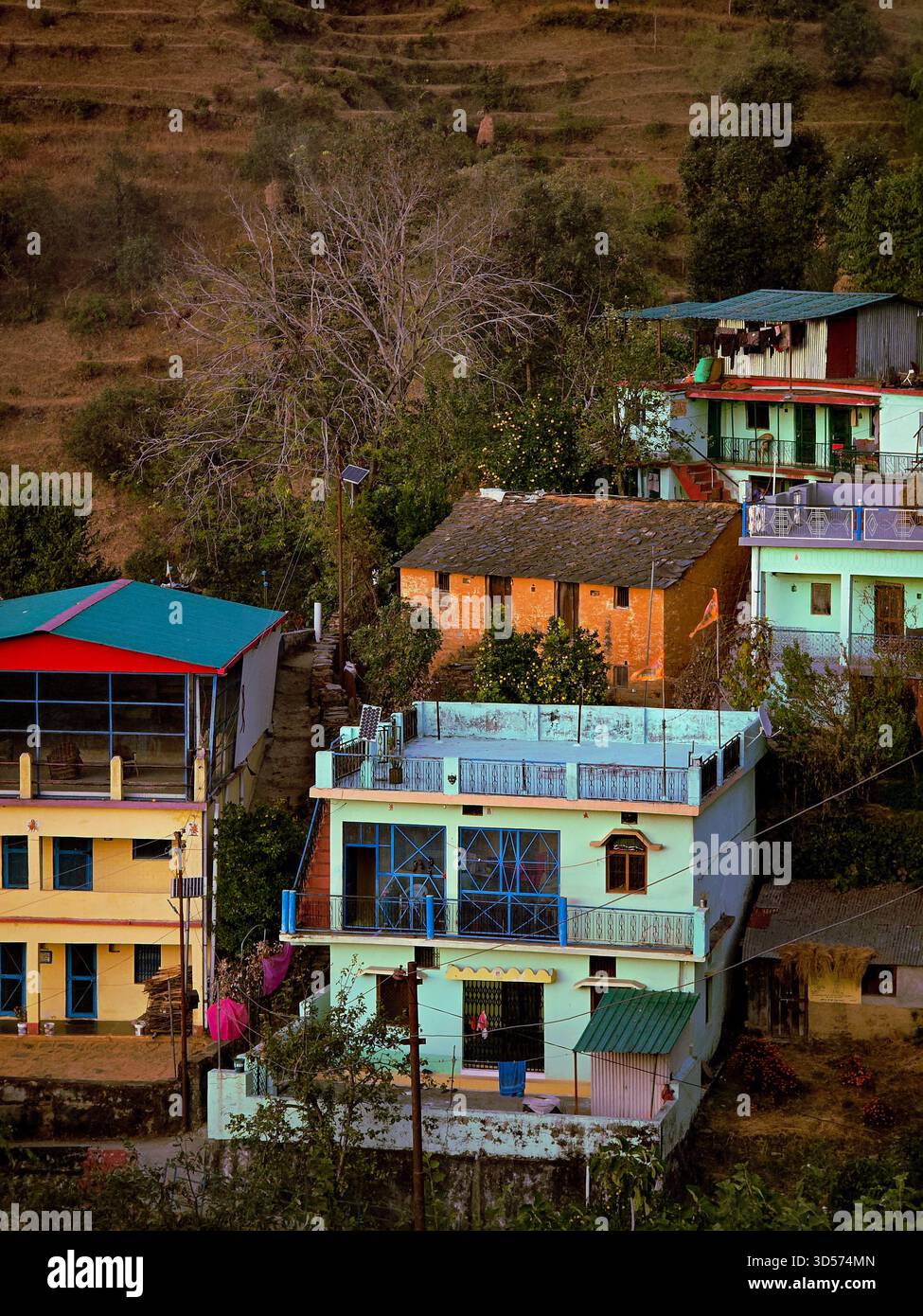 A colorful hillside village home surrounded by terraced fields and lush greenery. Traditional architecture, peaceful mountain vibes, and warm rural ch - Smartphone Captured Stock Image