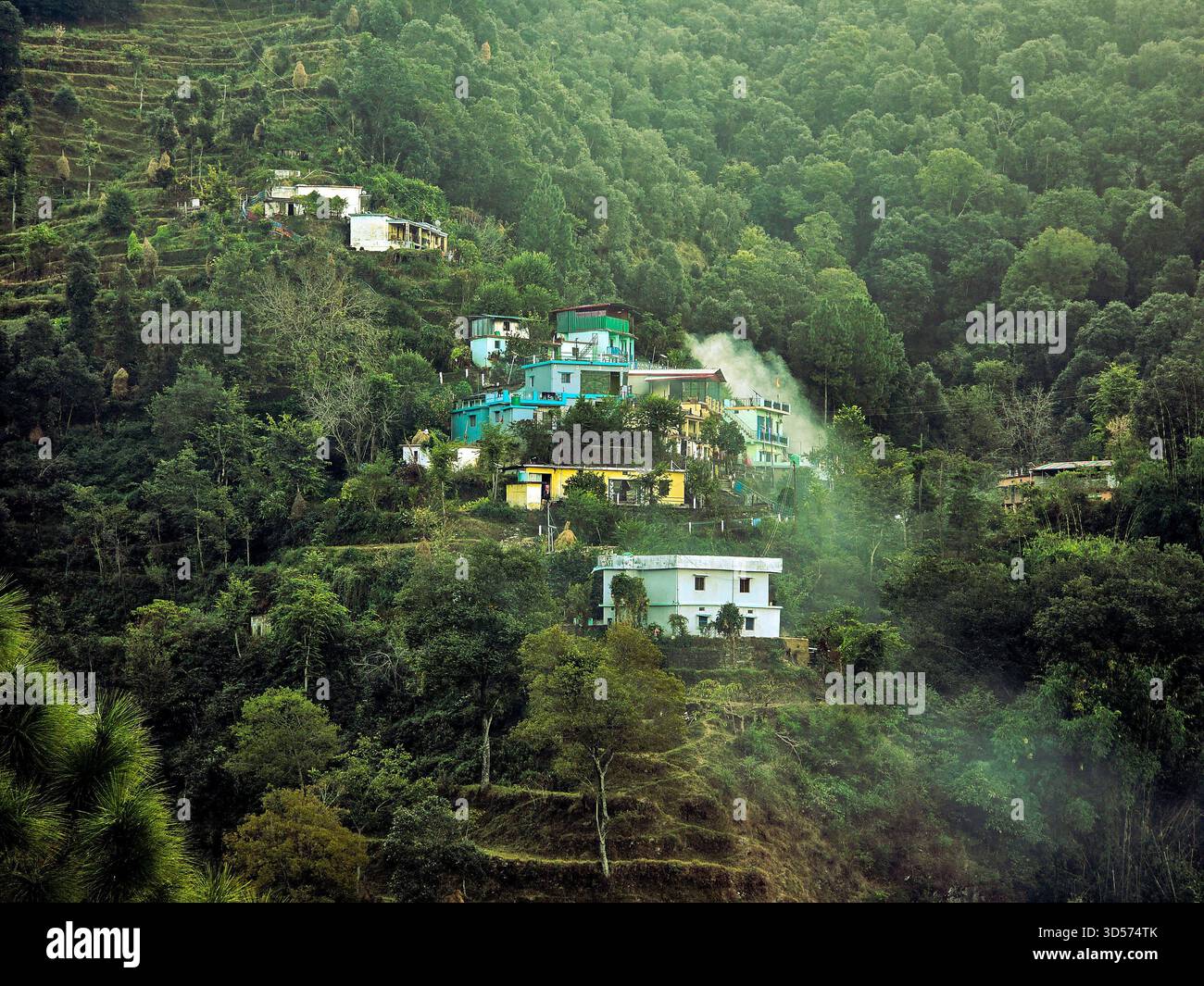 A peaceful hillside village surrounded by dense green forest, colorful homes, and misty air. The calm atmosphere and natural beauty create a perfect blend of serenity and mountain charm - Smartphone Captured Stock Image