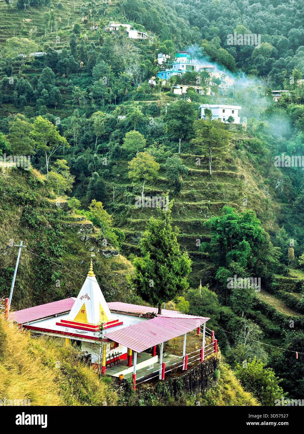 A peaceful hillside village surrounded by dense green forest, colorful homes, and misty air. The calm atmosphere and natural beauty create a perfect blend of serenity and mountain charm - Smartphone Captured Stock Image
