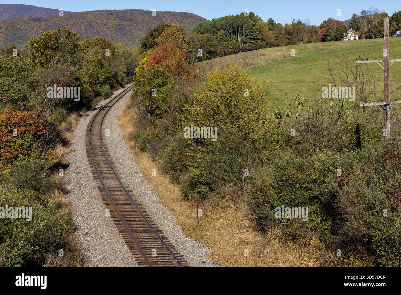 Empty train tracks going through hilly farmland landscape Stock Photo