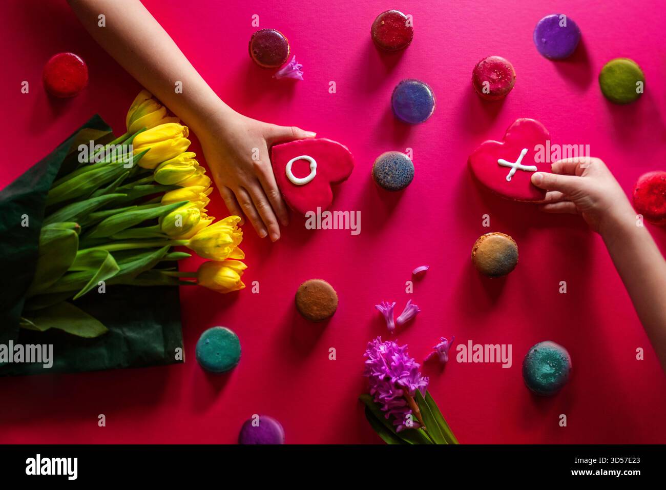 Hands holding Valentine Cookies with flowers and Pink background Stock Photo