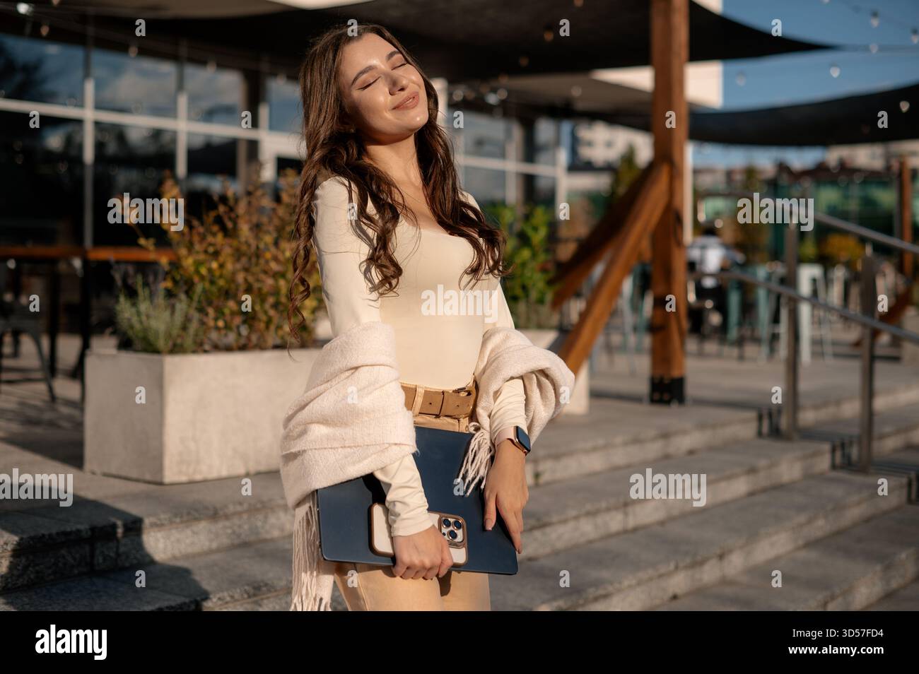 Young Woman Enjoying Sunlight with Laptop Outdoors Stock Photo