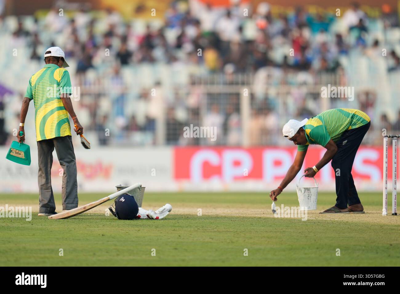Groundsmen clean the pitch area during a drinks break on the first day ...
