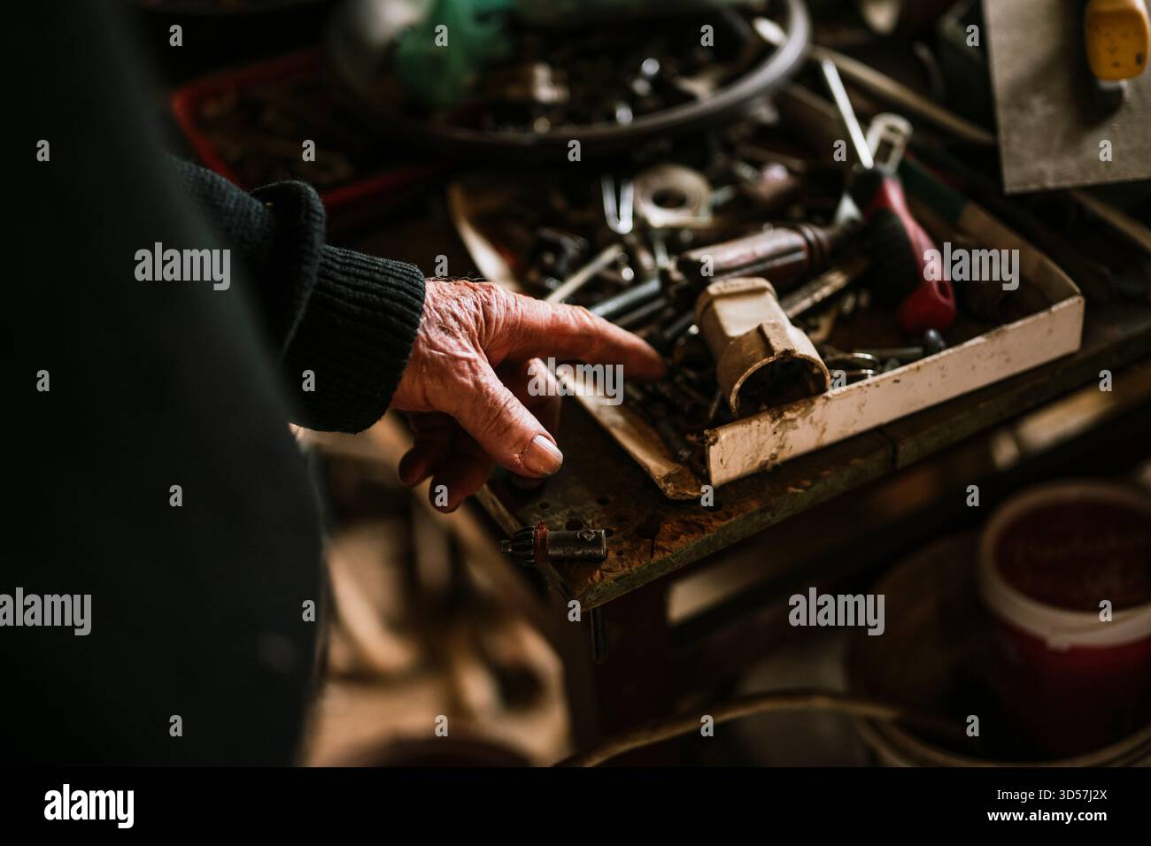 Finding tools in a cluttered workspace filled with various hand tools Stock Photo