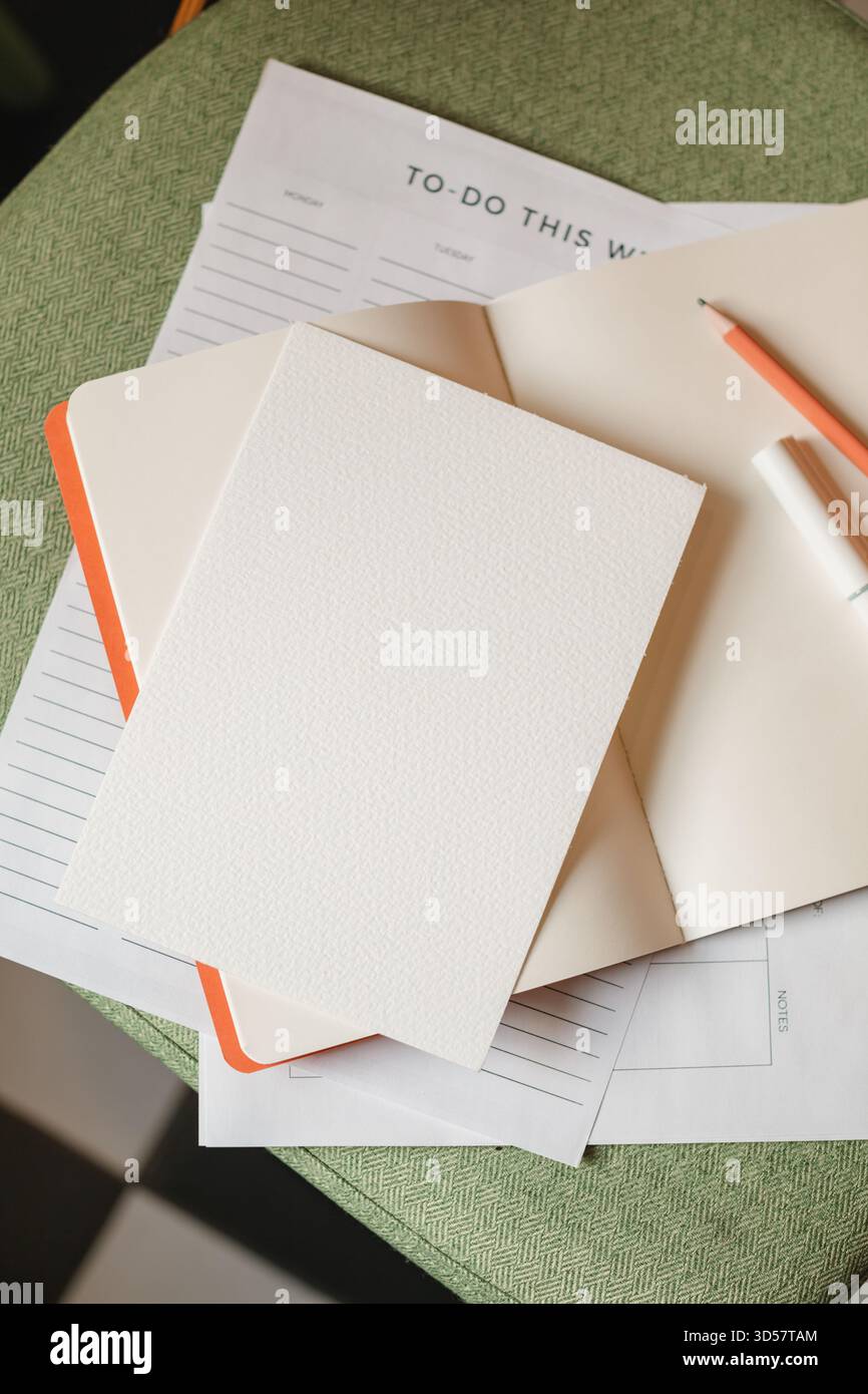 Close-up overhead view of a to do list on a chair with an open notebook, pen and pencil Stock Photo