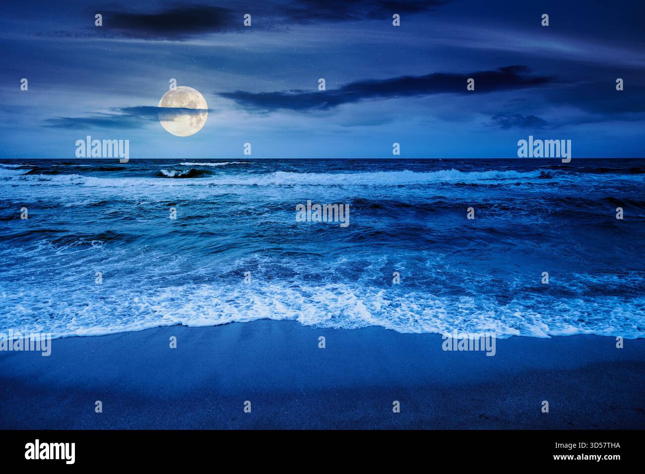 black sea waves crashing sandy beach at night. summer vacation on a windy weather under dark cloudy sky in full moon light. view of dramatic seascape. Stock Photo