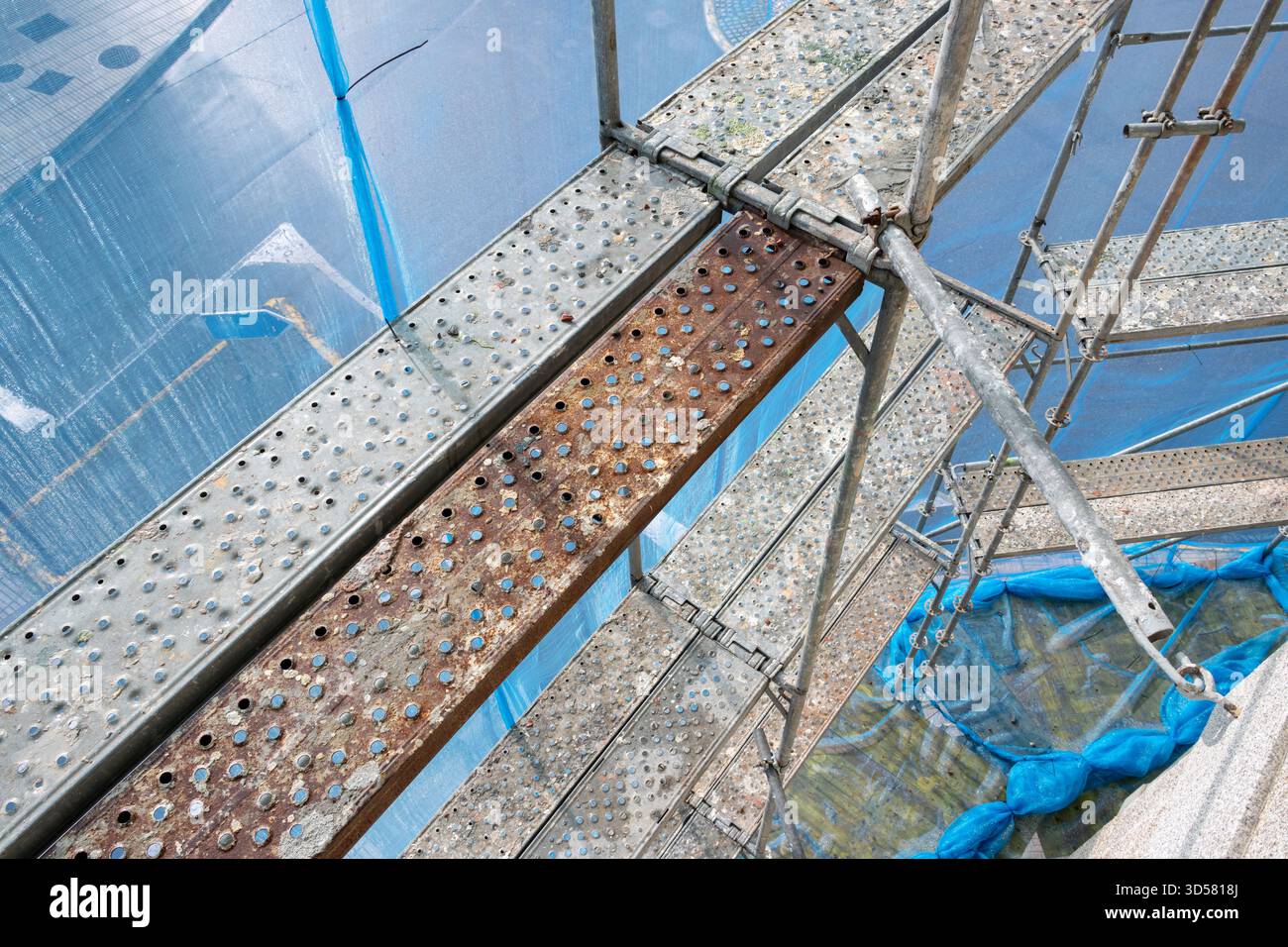 Scaffolding structure providing temporary access with platforms and protective netting Stock Photo