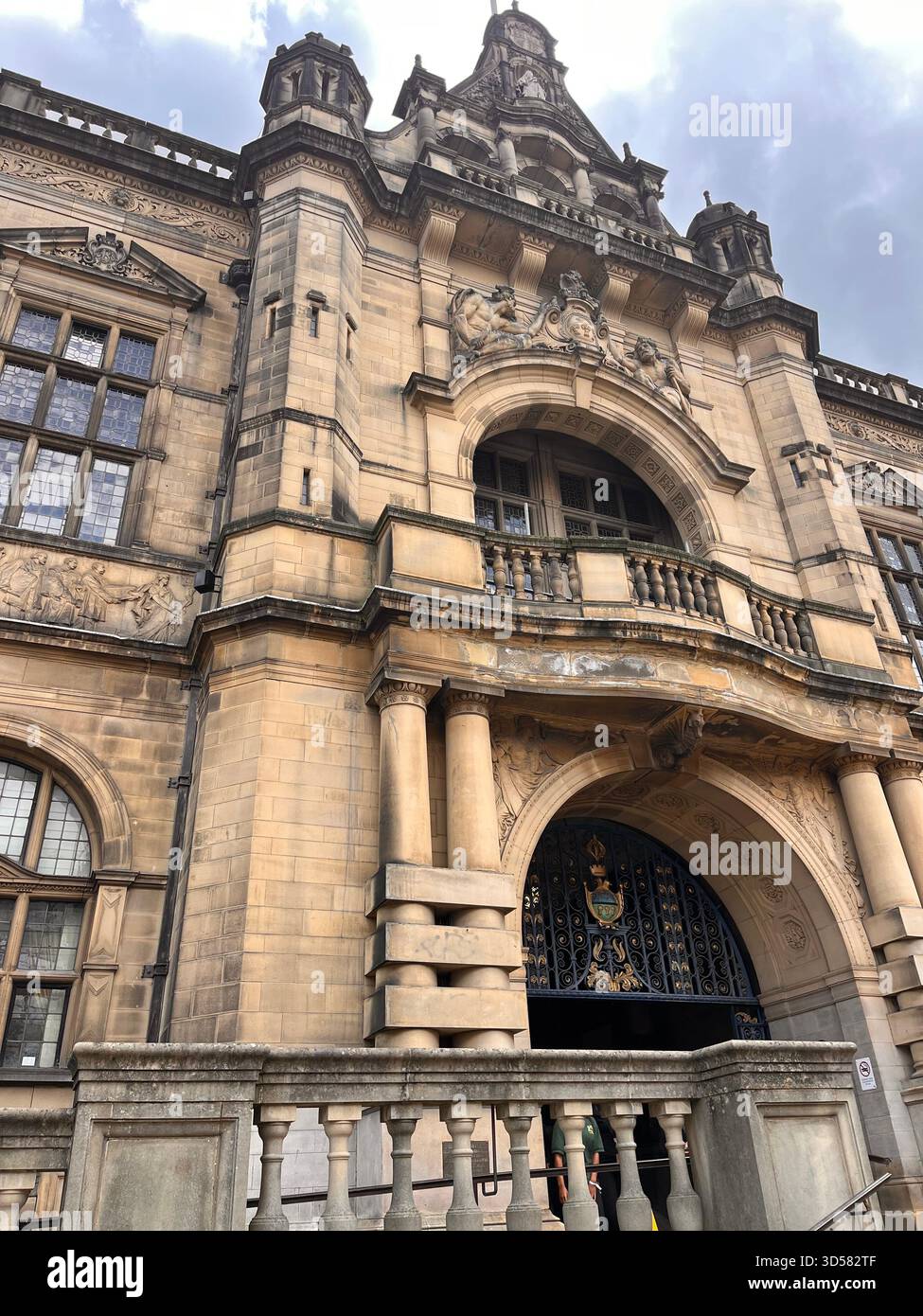 A richly detailed historic building in Sheffield featuring a grand arched entrance, intricate stonework, and sculptural elements. - Smartphone Captured Stock Image