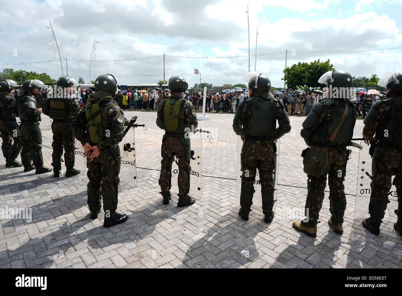 Attendees line up outside a fence to get into the venue for the COP30 U ...