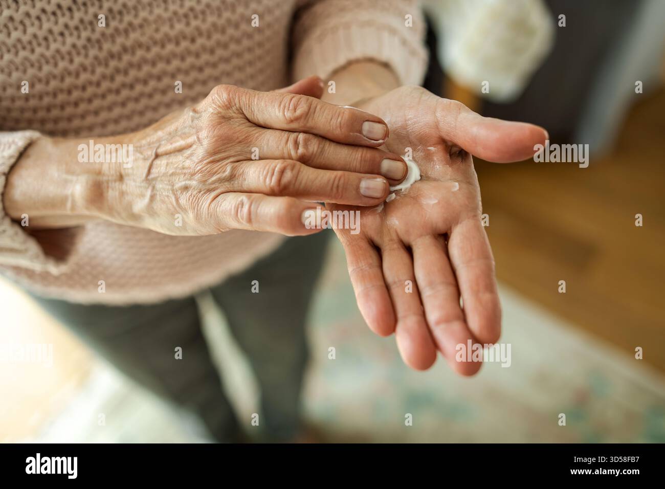 Senior woman applying moisturizer to her hands, close-up Stock Photo