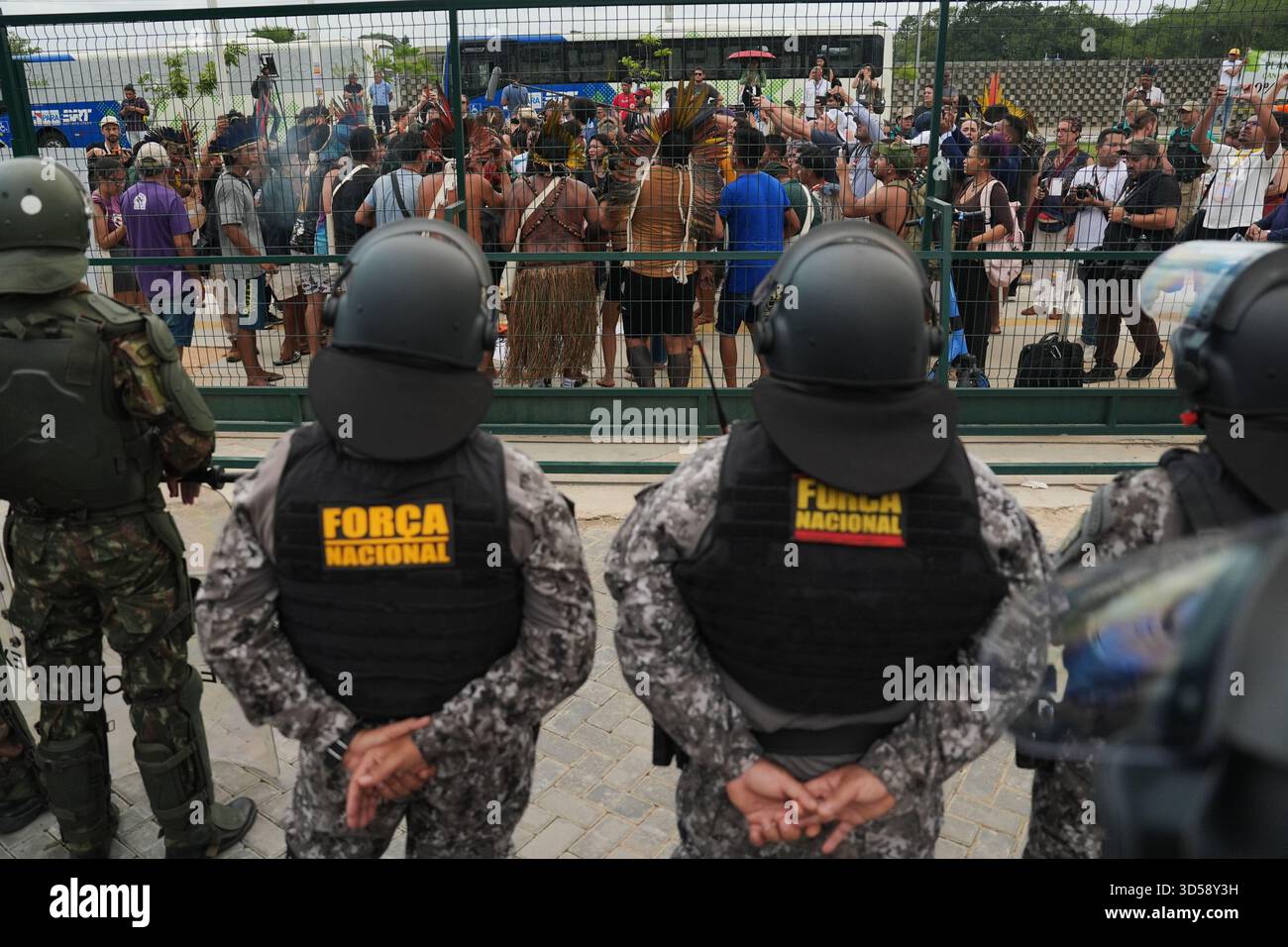 People gather outside a fence surrounding the COP30 U.N. Climate Summit ...