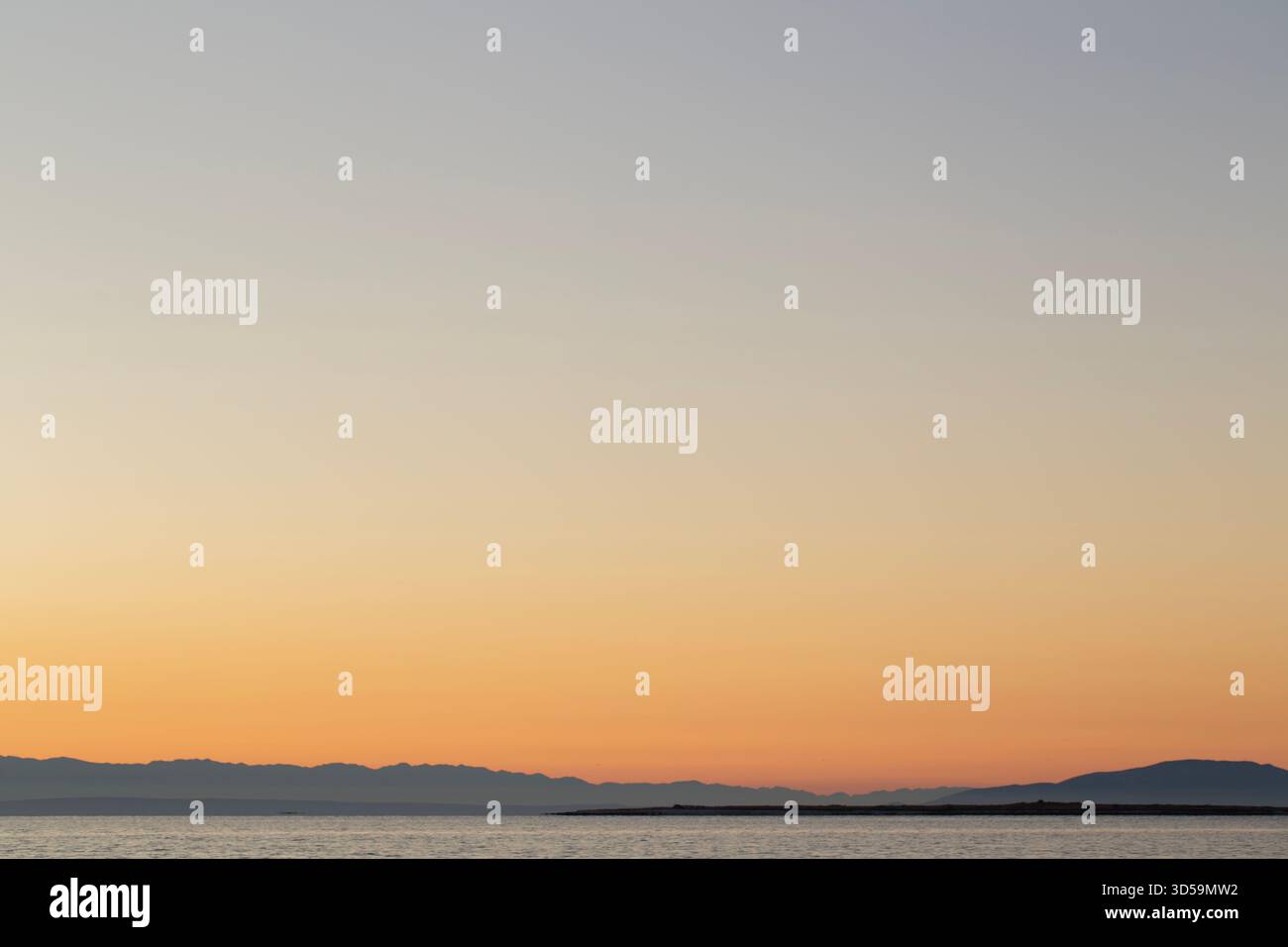 Minimal seascape at sunset with wide sky and warm colors. Stock Photo