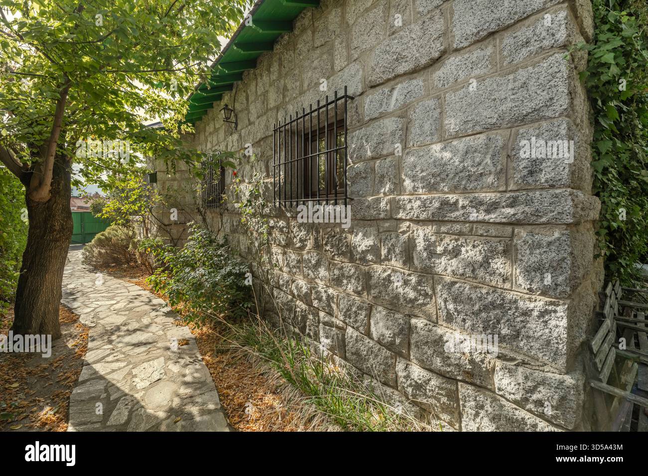 A perimeter path is paved with granite slabs of varying sizes and adorned with centuries-old olive trees planted alongside the stone wall, creating fo Stock Photo