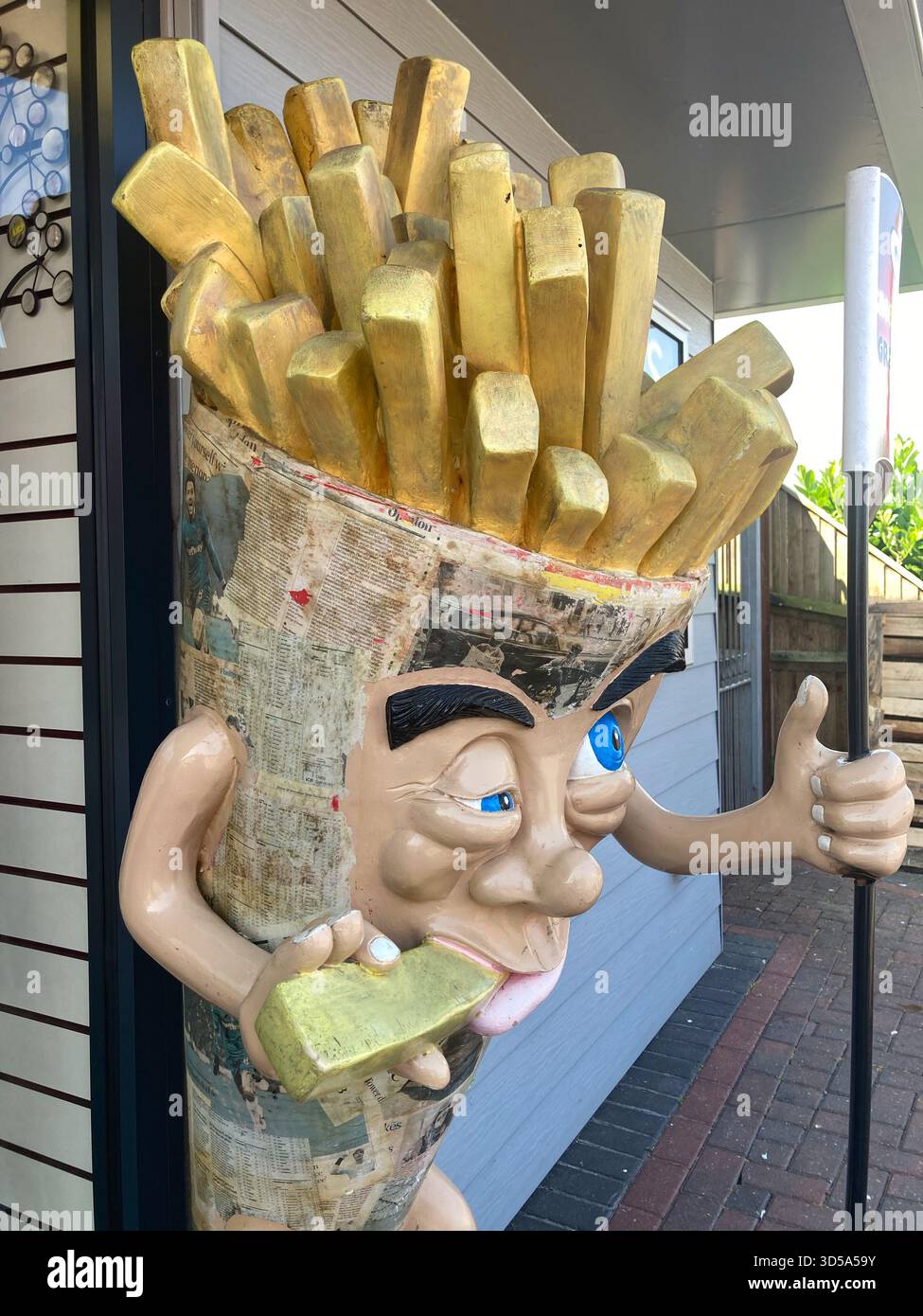 A chip cone figure statue outside a cafe in Hemsby near Great Yarmouth in Norfolk - Smartphone Captured Stock Image