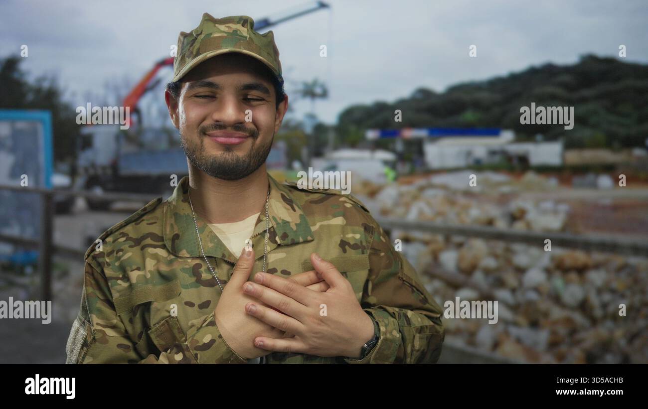 Man wearing camouflage cap and uniform smiles while holding hand to ...