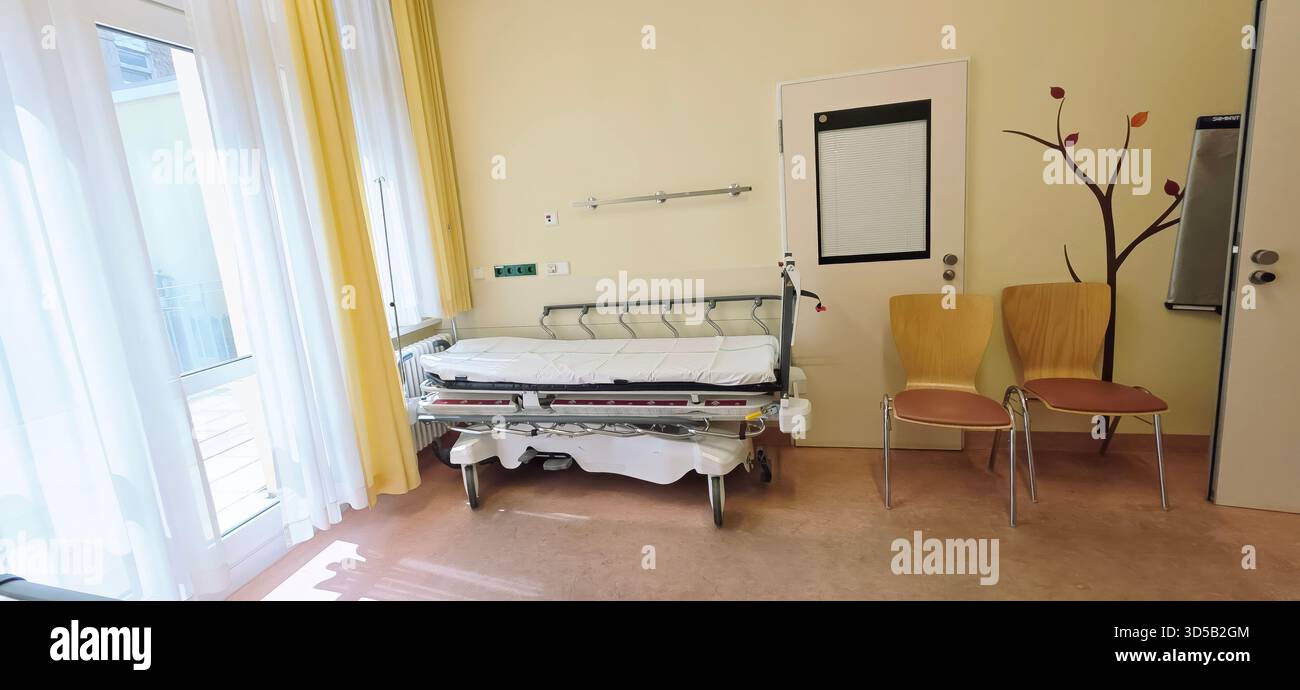 Berlin, Germany - June 16, 2025: Hospital room features an empty bed and chairs, illuminated by bright natural light. - Smartphone Captured Stock Image