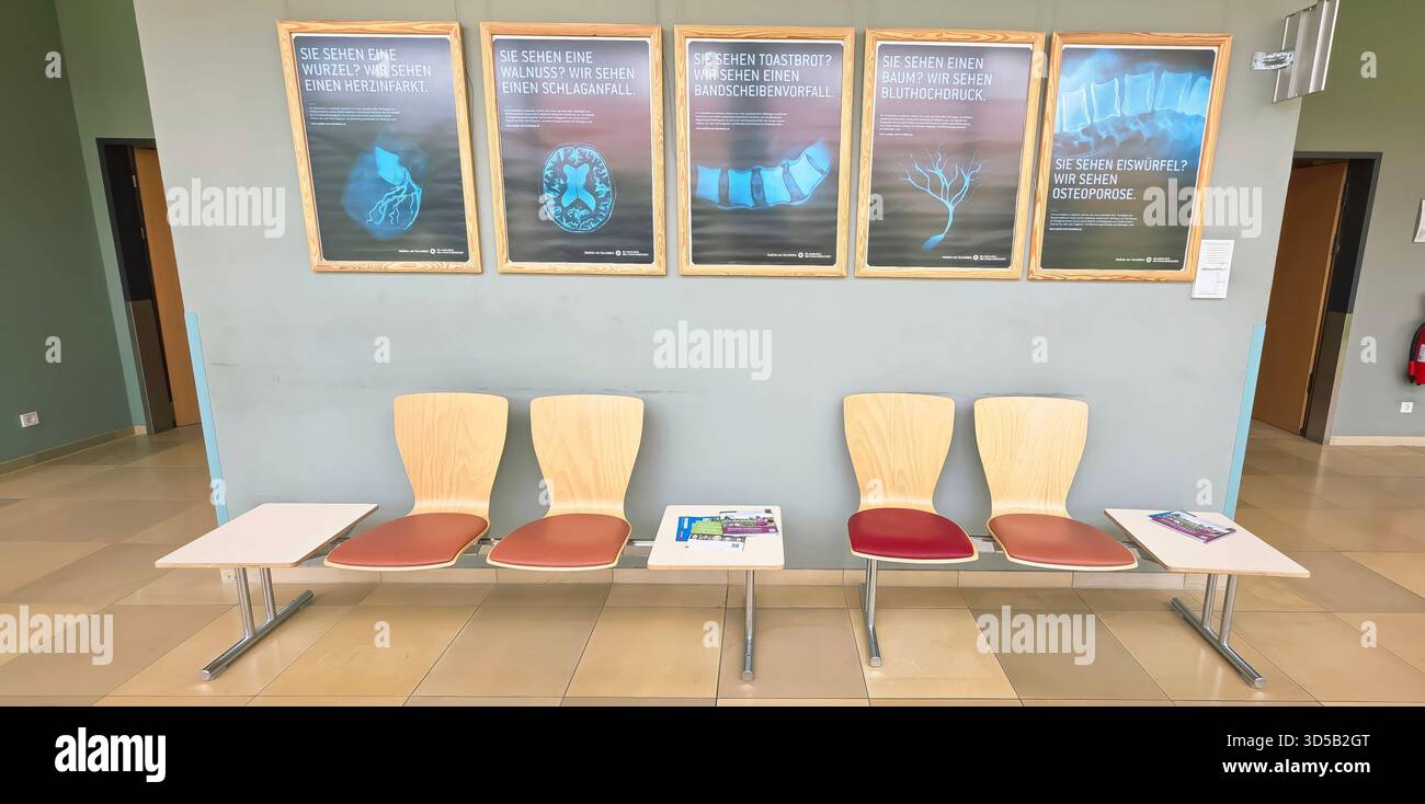 Berlin, Germany - June 16, 2025: Modern waiting area features wooden chairs and informative posters on the wall. - Smartphone Captured Stock Image