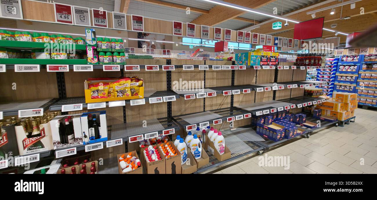 Berlin, Germany - June 28, 2025: Supermarket shelves display limited stock with empty spaces in grocery store environment. - Smartphone Captured Stock Image