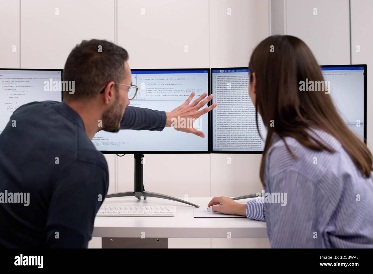 Agile Pair Programming And Extreme Coding: Two Developers Collaborating At Desks. Stock Photo