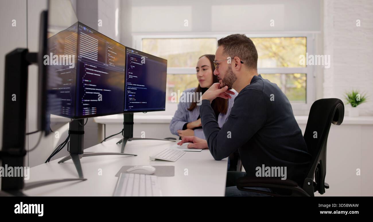 Two Young Caucasians Collaborating On PC Engineering Code Development Project Stock Photo