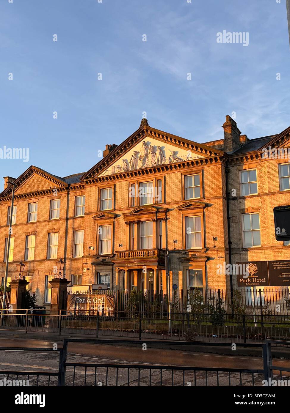 Elegant Victorian style building illuminated by warm evening sunlight in Hull, England. Detailed facade and classic British architecture captured - Smartphone Captured Stock Image
