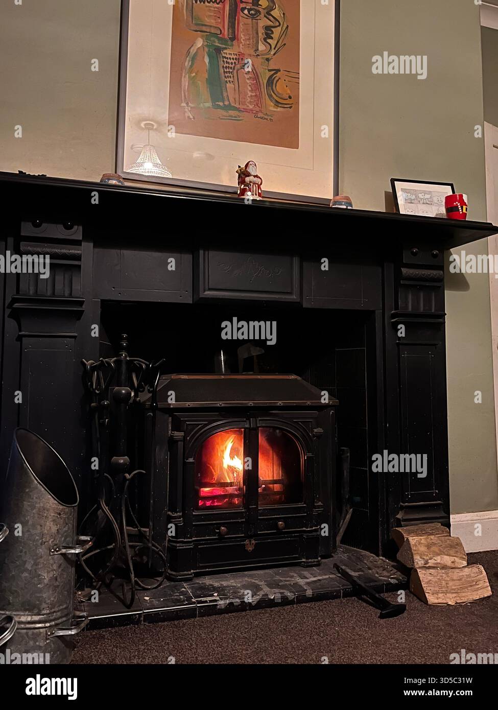 Warm and cozy living room interior in Hull, England, featuring a traditional wood-burning stove with glowing fire, creating a homely British winter at - Smartphone Captured Stock Image