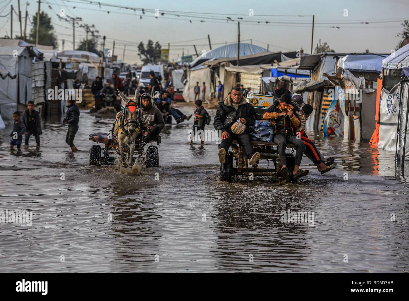 Khan Yunis, Palestinian Territories. 15th Nov, 2025. Palestinians use donkey carts to cross the flooded streets, as they endure the bitter cold and heavy rains that inundate their tents in the Al-Attar area of ··Mawasi, west of Khan Younis in the southern Gaza Strip. Credit: Abed Rahim Khatib./dpa/Alamy Live News Stock Photo