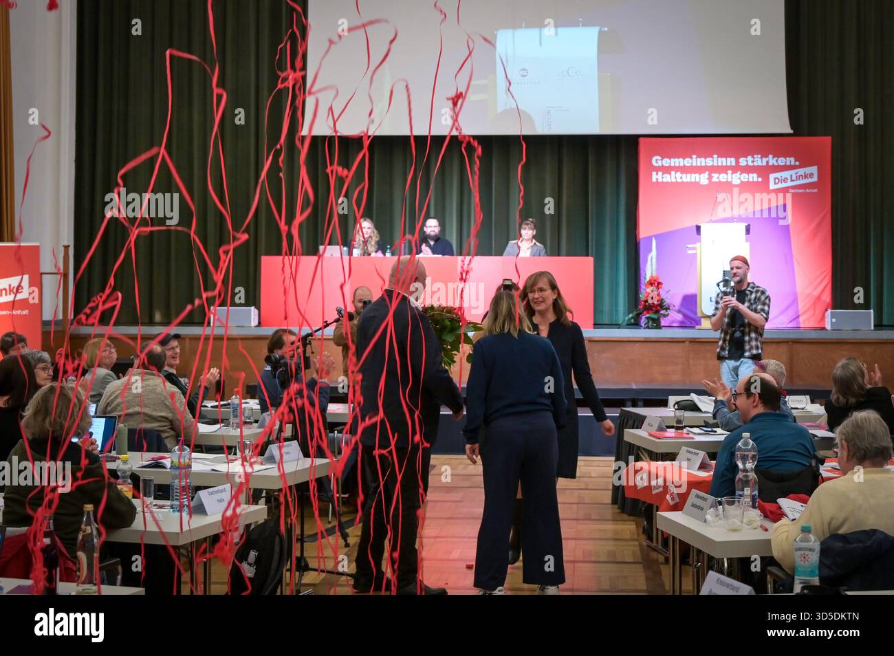 Leuna, Germany. 15th Nov, 2025. Red streamers fly through the hall after the vote on the main motion at the 10th state party conference of the Left Party of Saxony-Anhalt. The party conference focuses on preparations for the 2026 state elections. Credit: Heiko Rebsch/dpa/Alamy Live News Stock Photo
