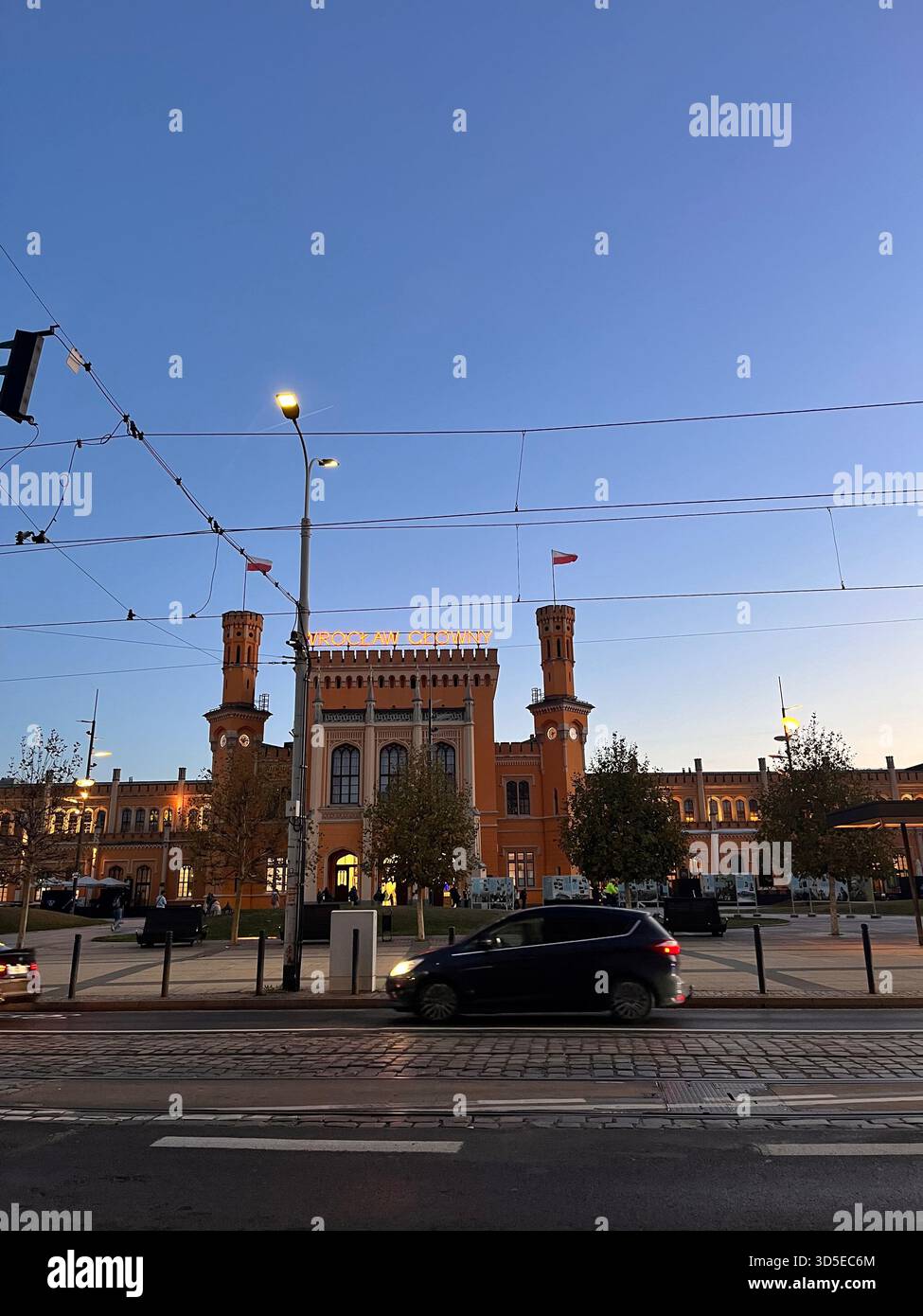 A striking neo-Gothic red-brick building with characteristic towers, photographed during sunset in Wrocław, Poland. - Smartphone Captured Stock Image