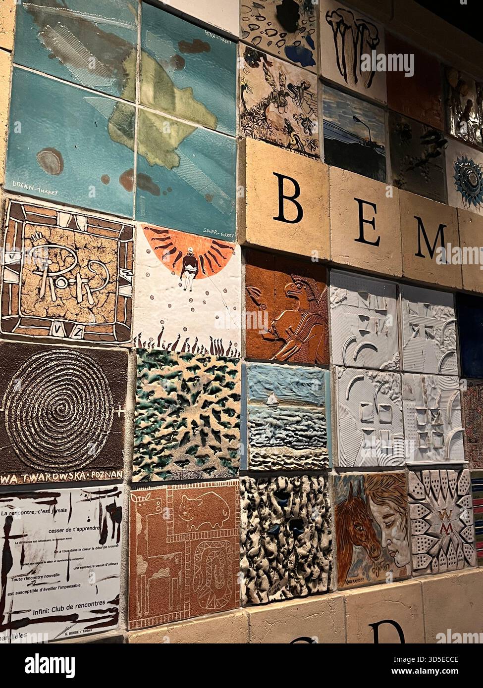 A colorful artistic installation composed of ceramic tiles, each featuring unique textured patterns and illustrations. Photographed in Wrocław, Poland - Smartphone Captured Stock Image