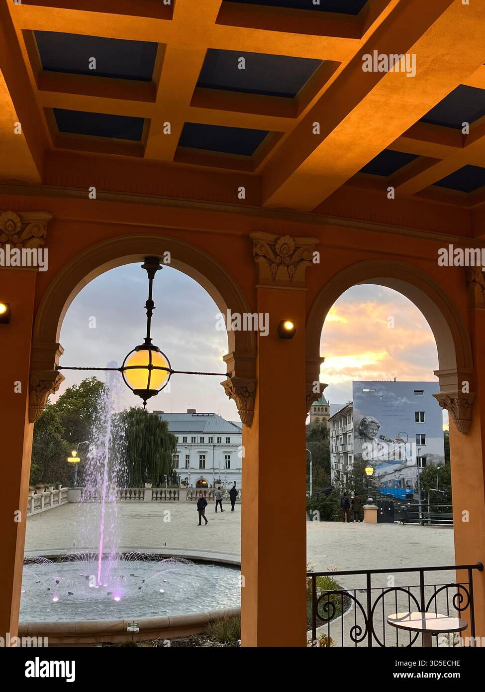 A warmly illuminated arcade ceiling with classic architectural details in Wrocław, Poland. The golden lighting enhances the structure’s geometry - Smartphone Captured Stock Image