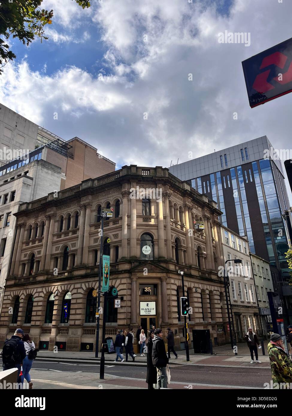 A street-level view of historic architecture in central Leeds, England, captured on a bright day with pedestrians walking through the city. - Smartphone Captured Stock Image