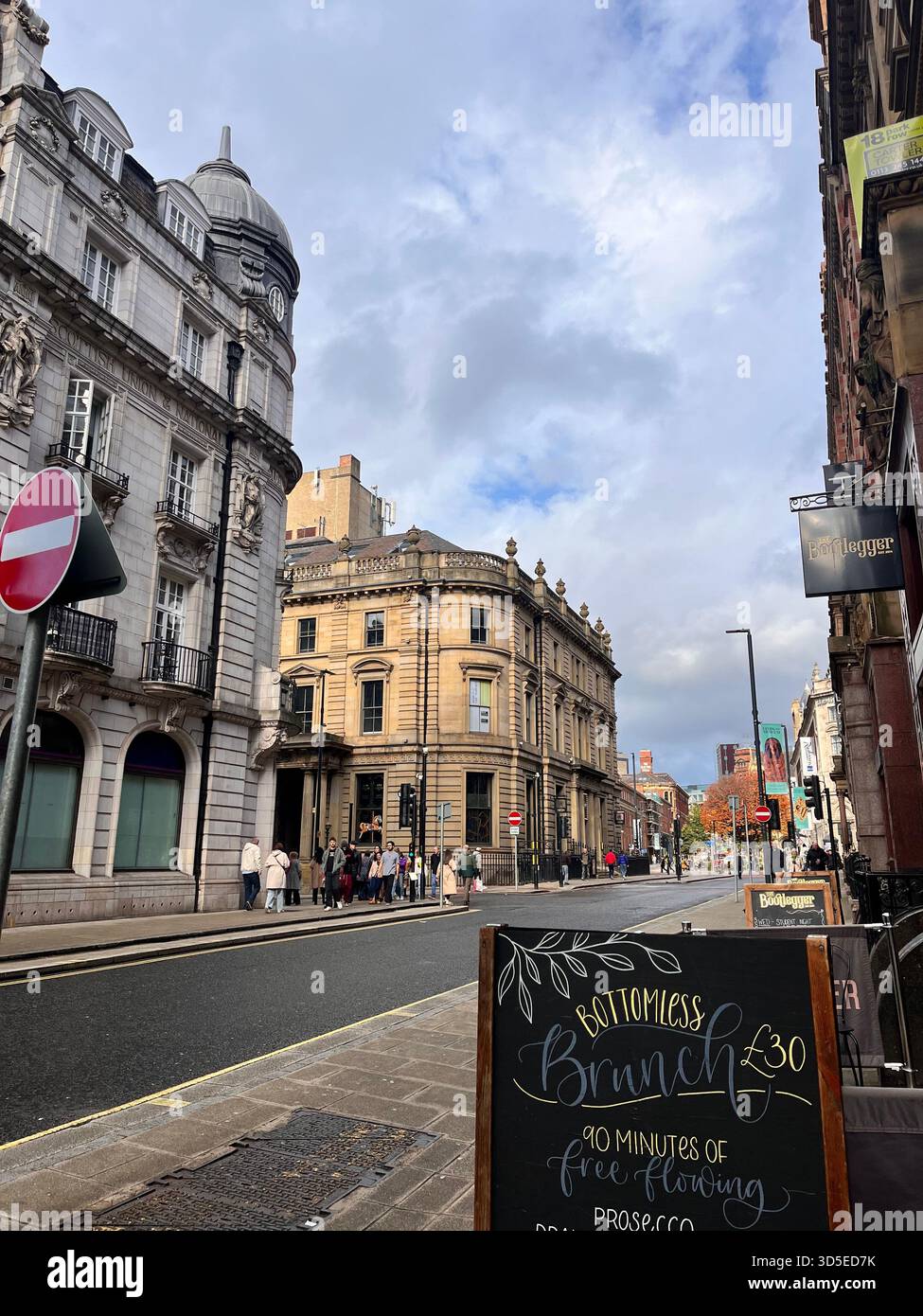 A lively street corner in central Leeds, England, showing beautifully preserved historic buildings, commercial signage, - Smartphone Captured Stock Image