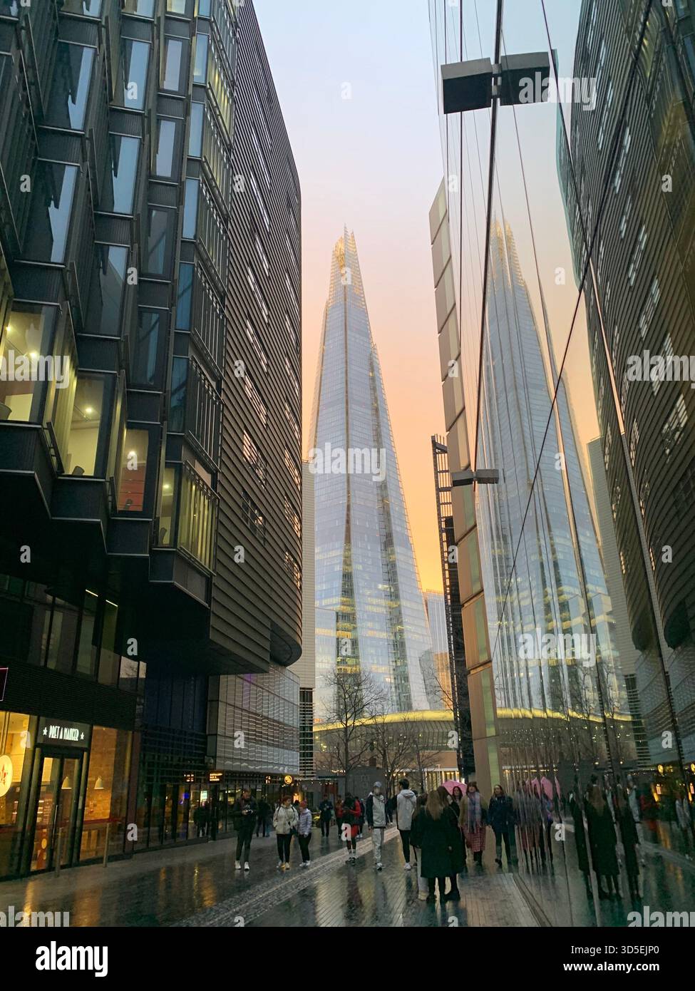 Street view featuring a historic London pub at sunset, with pedestrians and soft warm light. - Smartphone Captured Stock Image