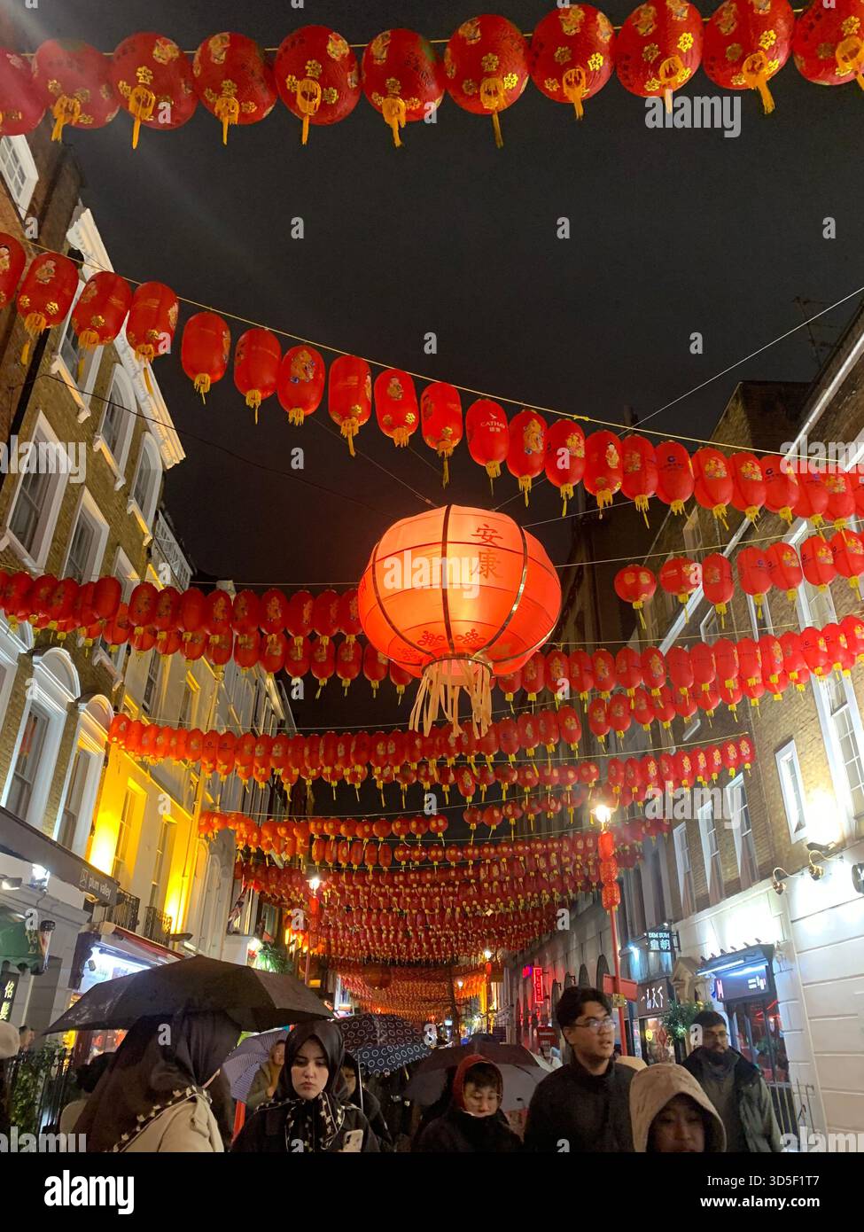 Festive red Chinese lanterns decorating Chinatown in central London at night, creating a vibrant cultural atmosphere. - Smartphone Captured Stock Image