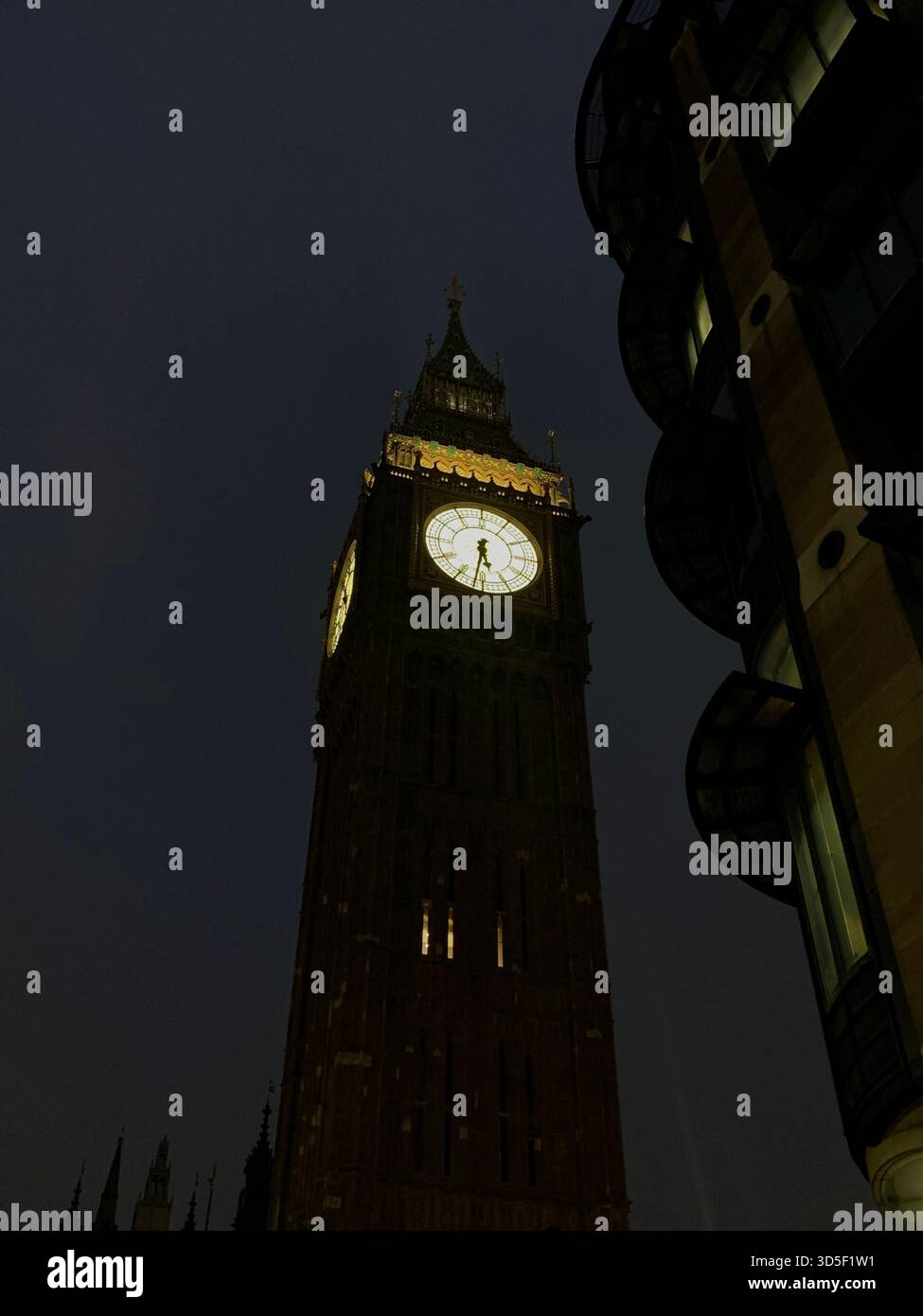 Close-up view of Big Ben clock tower illuminated against the night sky in London. World-famous symbol of the United Kingdom and British heritage. - Smartphone Captured Stock Image