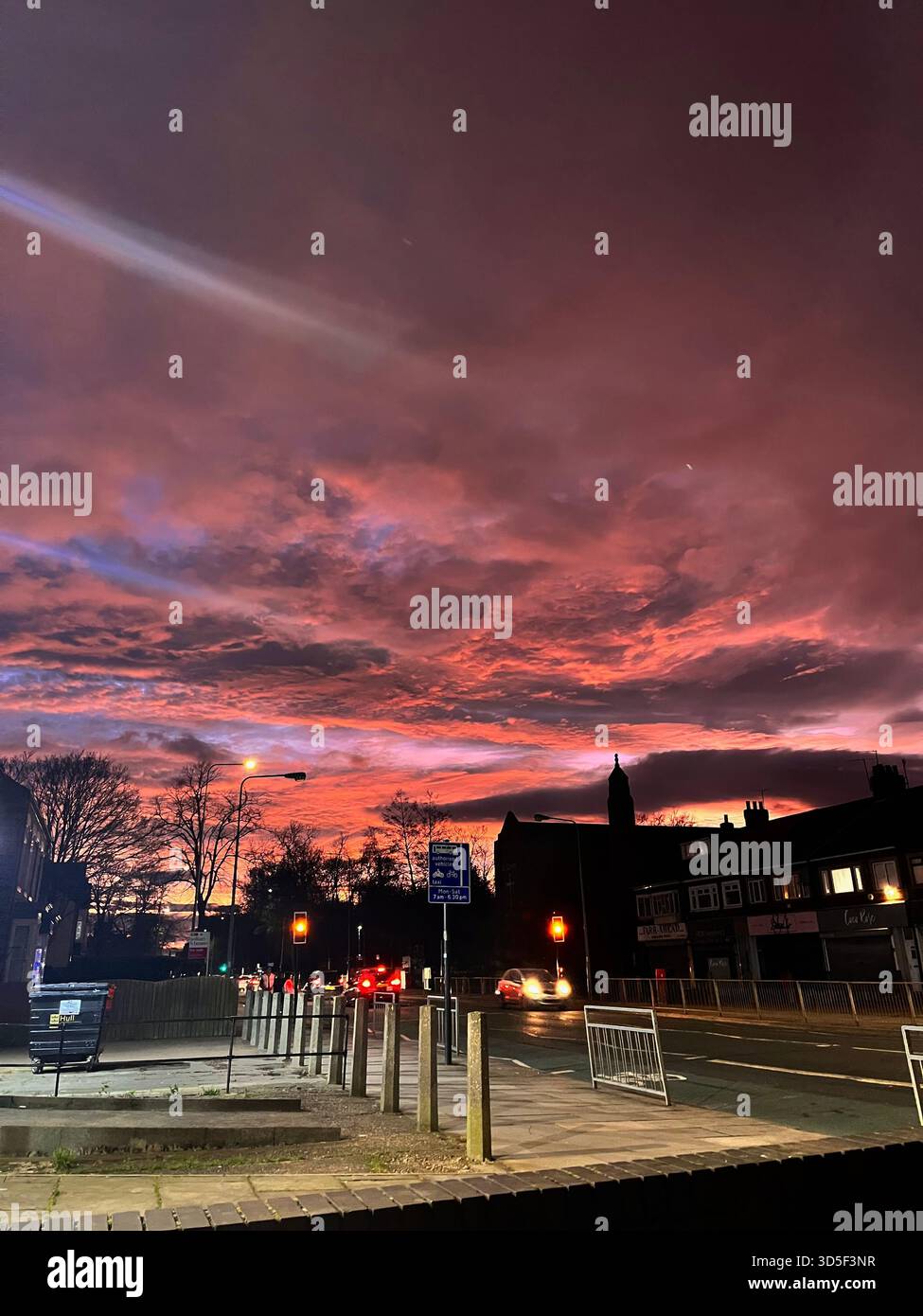 Urban street in Hull, England under a vivid dramatic sunset with colorful clouds and silhouettes of buildings. Atmospheric cityscape capturing evening - Smartphone Captured Stock Image