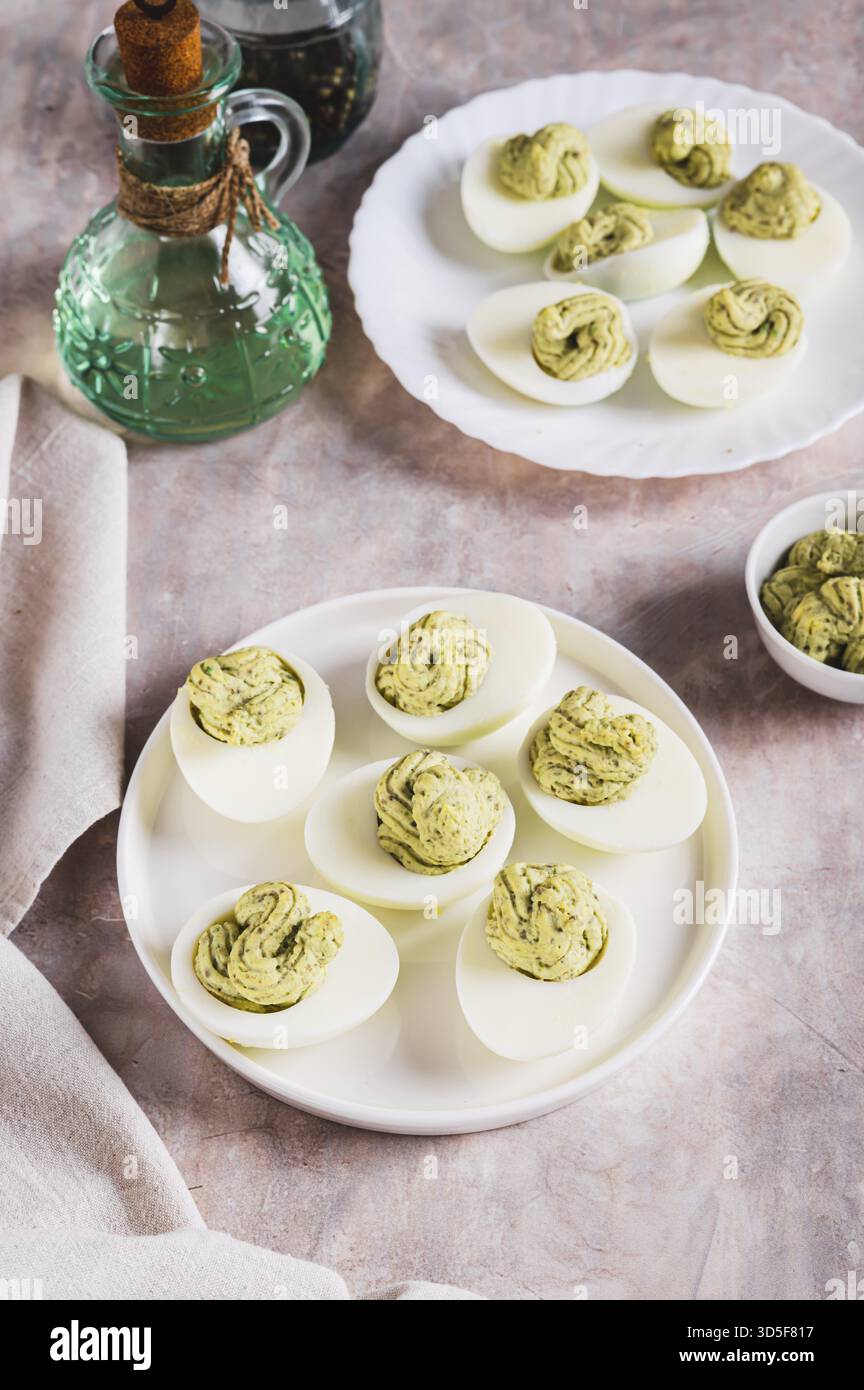 Avocado deviled eggs for appetizer on plate on table vertical view Stock Photo