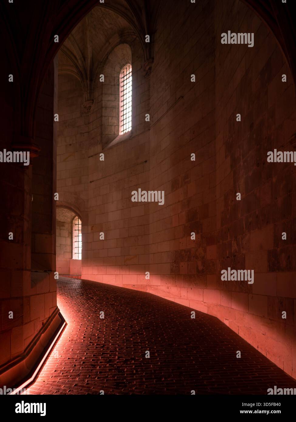 Atmospheric castle interior with a historic spiral ramp illuminated by ...