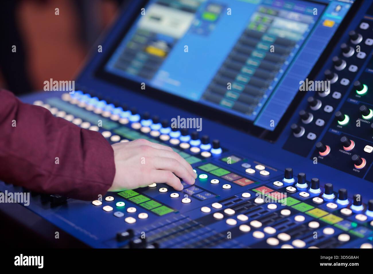 Sound engineer controls live sound mixing digital console. Selective focus. Stock Photo