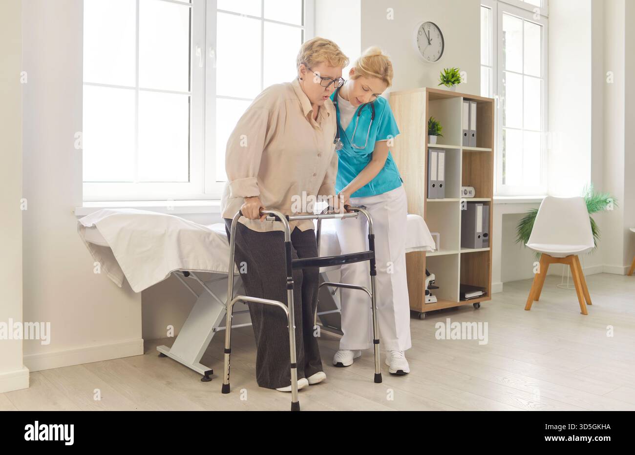 Nurse helping elderly woman walk with walker Stock Photo - Alamy
