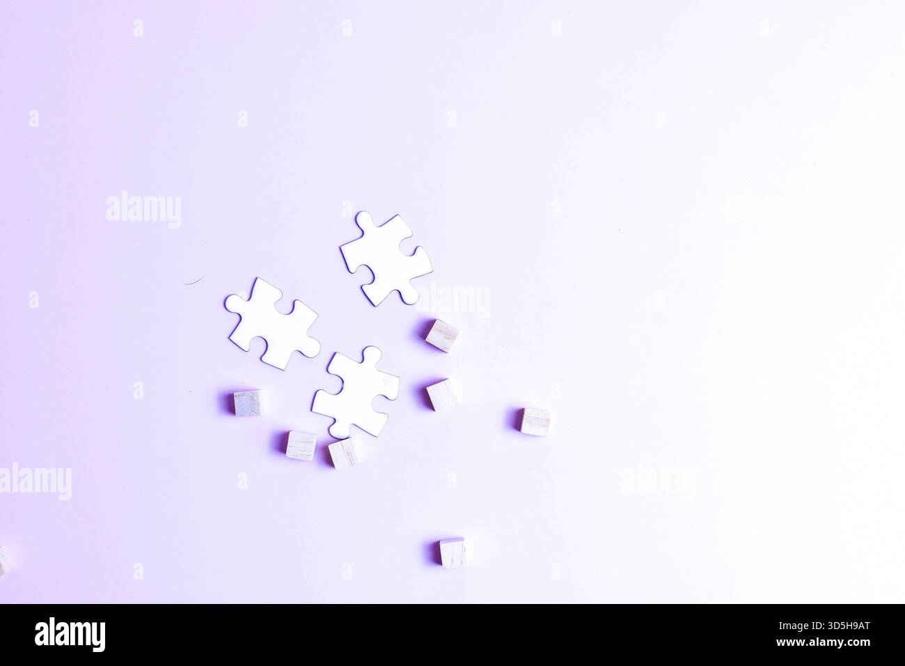 White puzzle pieces and scattered cubes on purple surface symbolize problem-solving, creativity, and contrast between structure and randomness. Stock Photo
