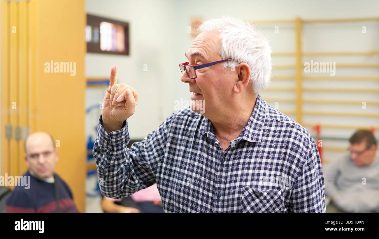 Senior man using sign language, promoting inclusive language Stock Photo