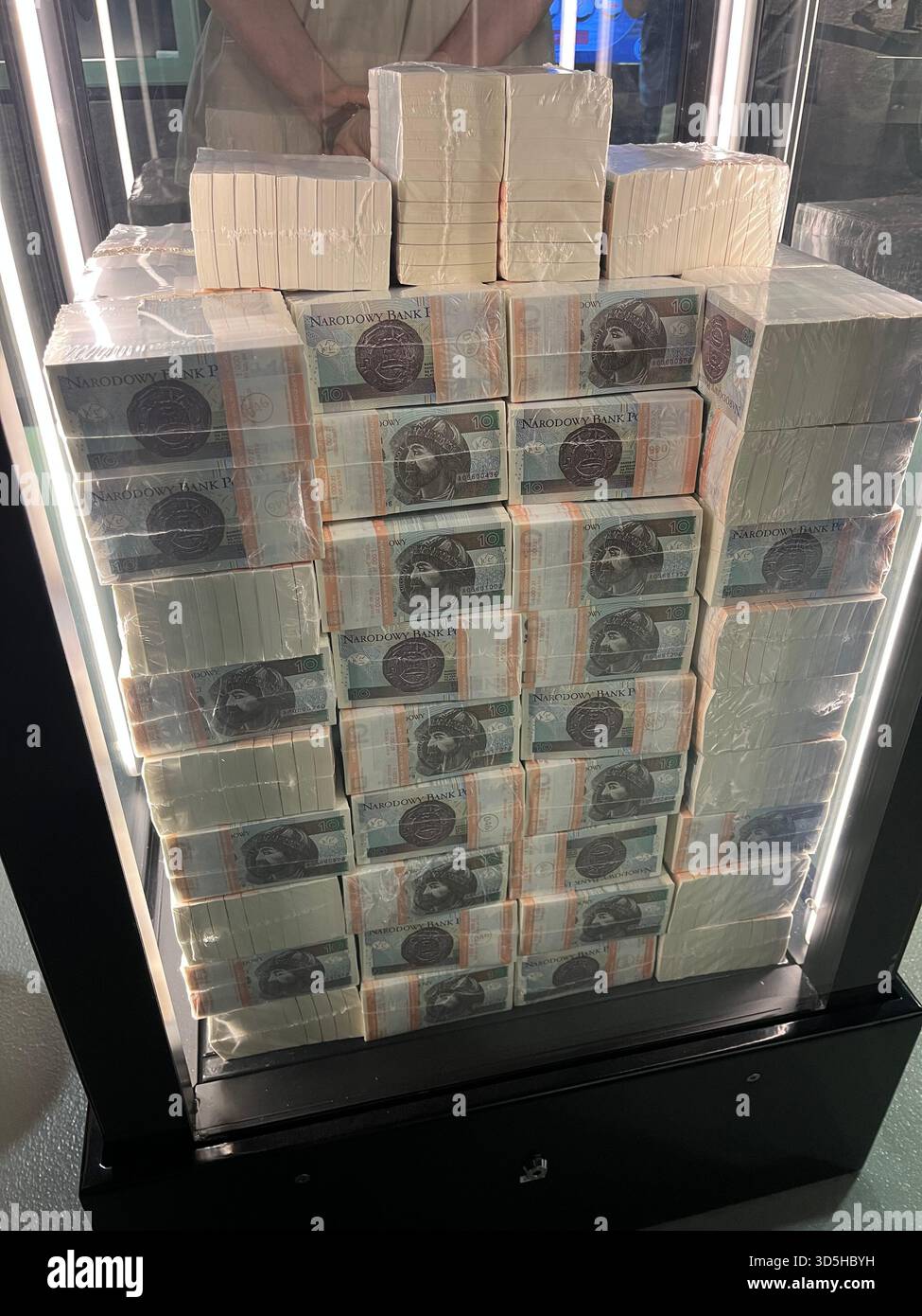 Stacked Polish banknotes displayed behind glass in Warsaw, Poland. Financial concept, economy, savings, and currency background. - Smartphone Captured Stock Image