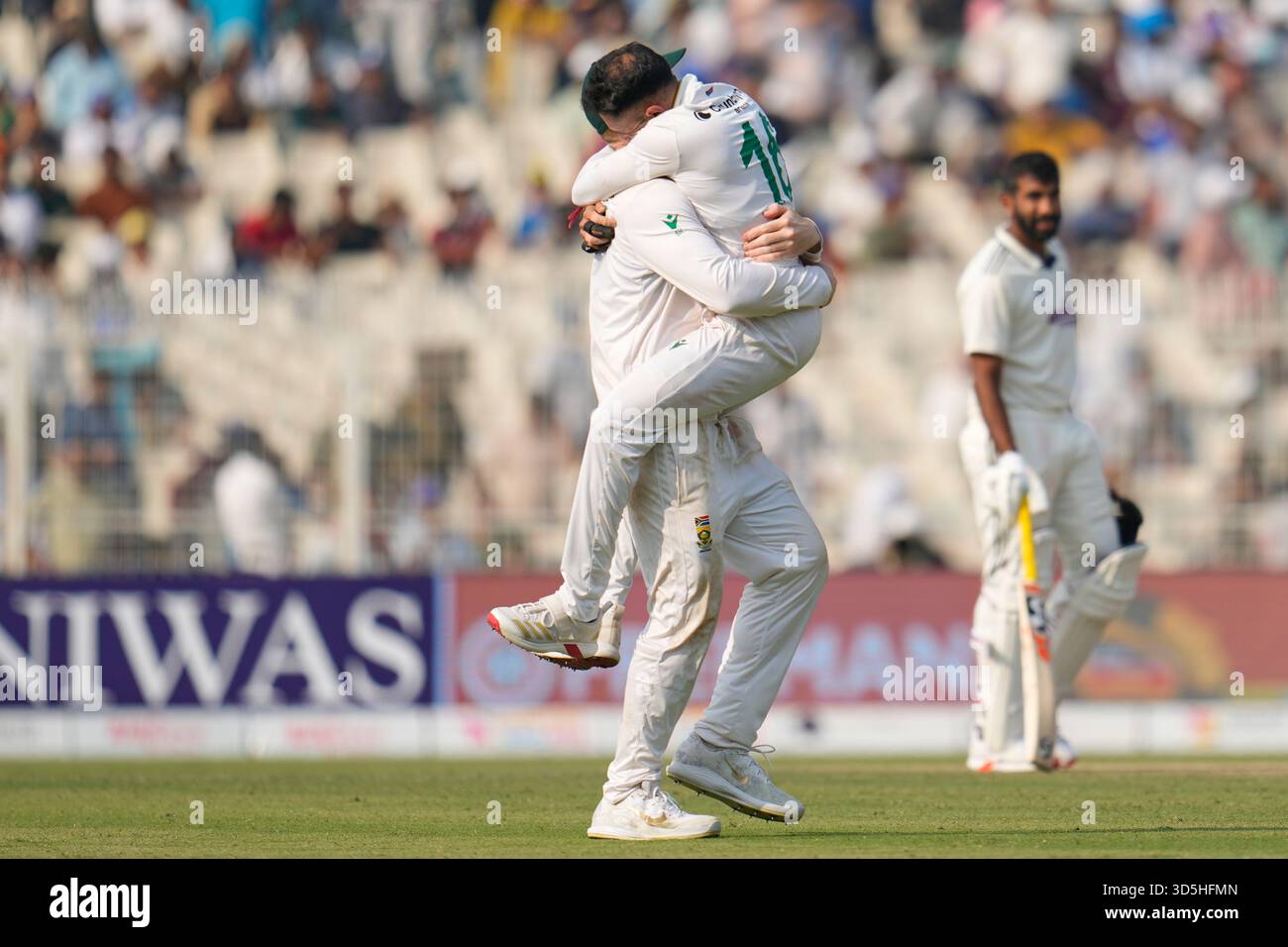 India's Jasprit Bumrah, right, watches as South Africa's Simon Harmer ...