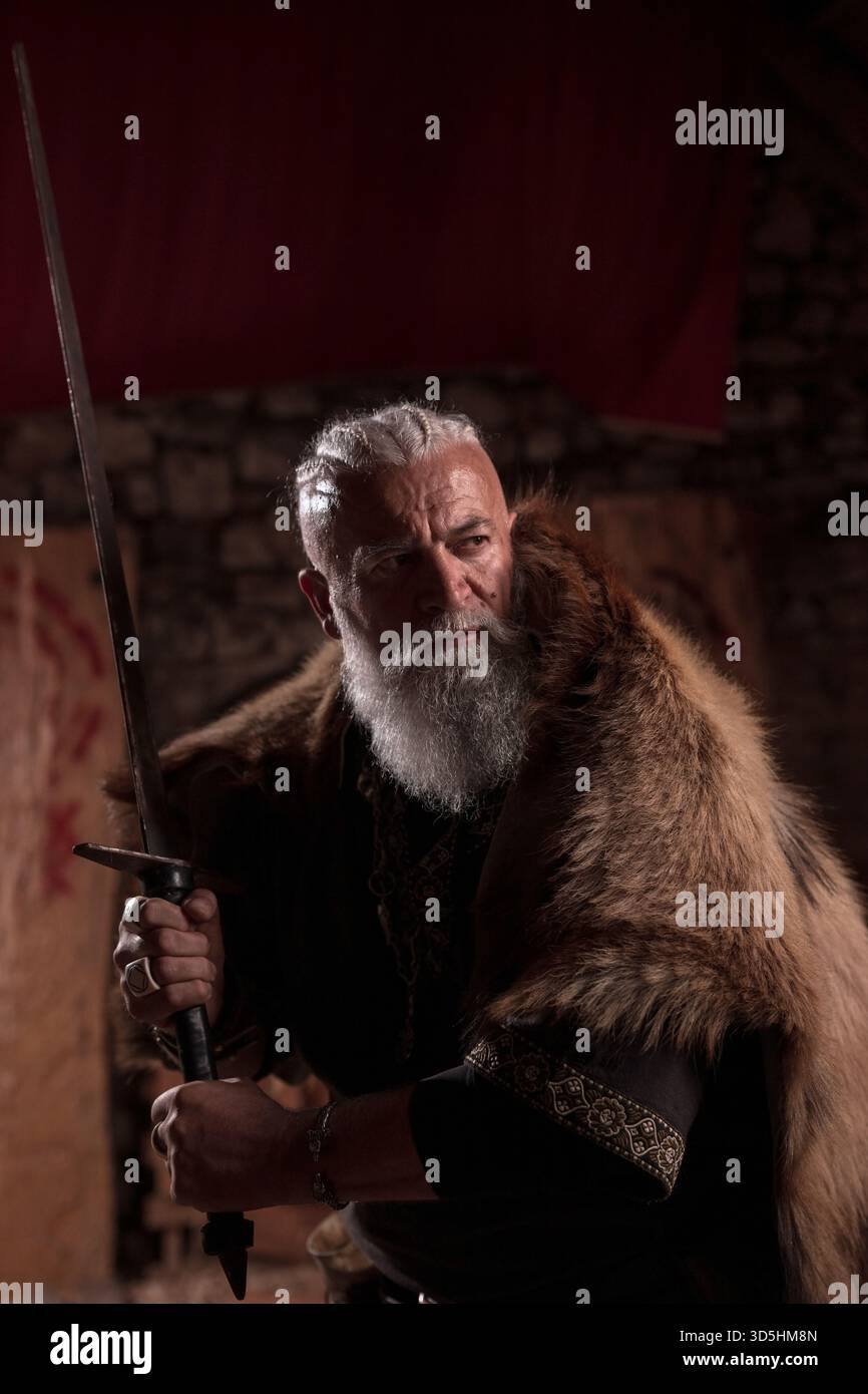 A stern Viking chieftain with a formidable white beard and braided hair ...