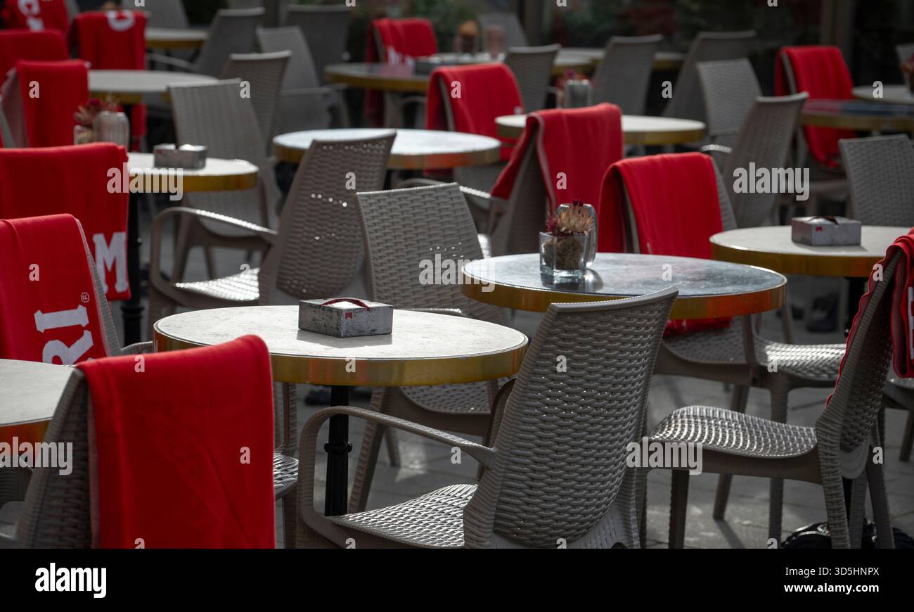 Munich, Germany. 16th Nov, 2025. In a street café, the sun shines weakly on empty tables with chairs and blankets. After a mixed Sunday, the weather is set to become much colder and wetter at the start of the week. Credit: Stefan Puchner/dpa/Alamy Live News Stock Photo