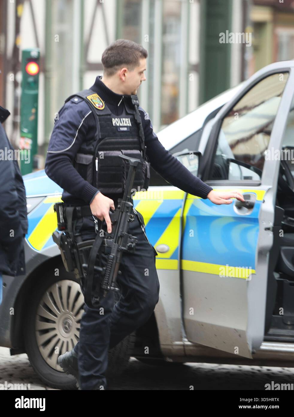 Wernigerode, Germany. 16th Nov, 2025. A police officer carries his weapon in his hand during a police operation. The police had cordoned off the market square, more detailed information was not yet available. Credit: Matthias Bein/dpa/Alamy Live News Stock Photo