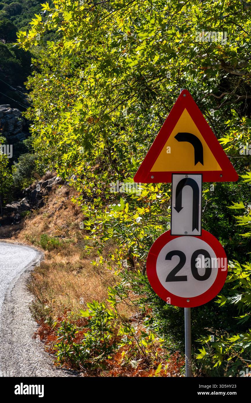 Sharp Incliine Sign Sharp curve warning sign on bright rural road, with speed limit marker ...