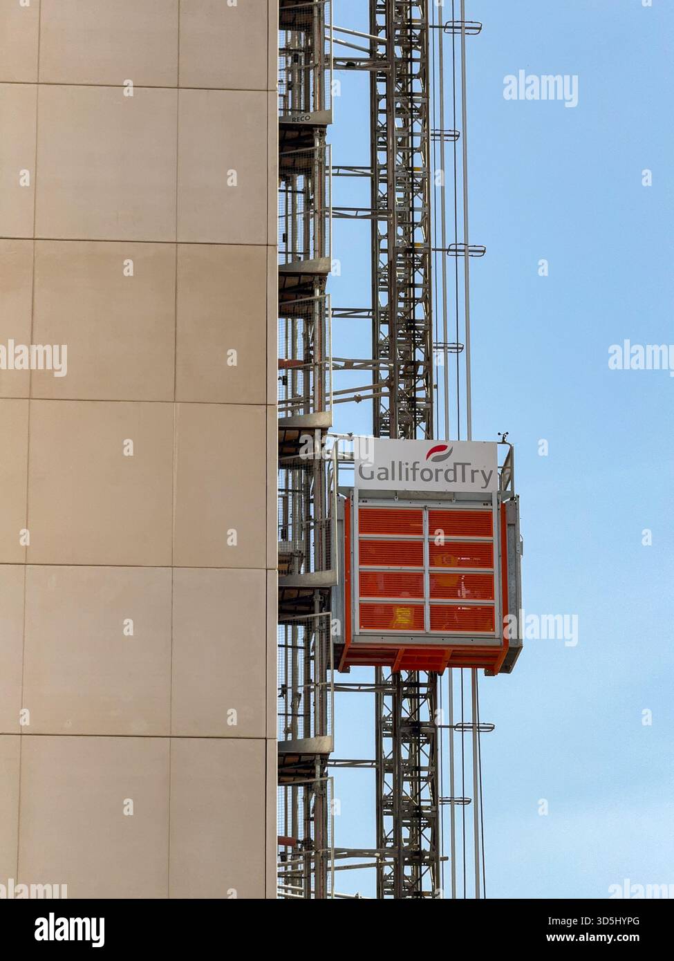 Cardiff, Wales, UK - 15 August 2025: Construction workers working for Galliford Try in an elevator on the outside of a block of apartments in Cardiff - Smartphone Captured Stock Image